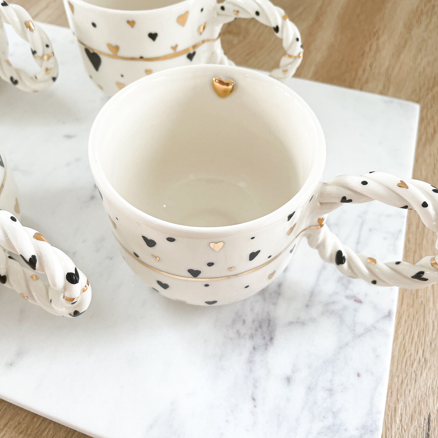 Tasse mit schwarzen und goldenen Herzen