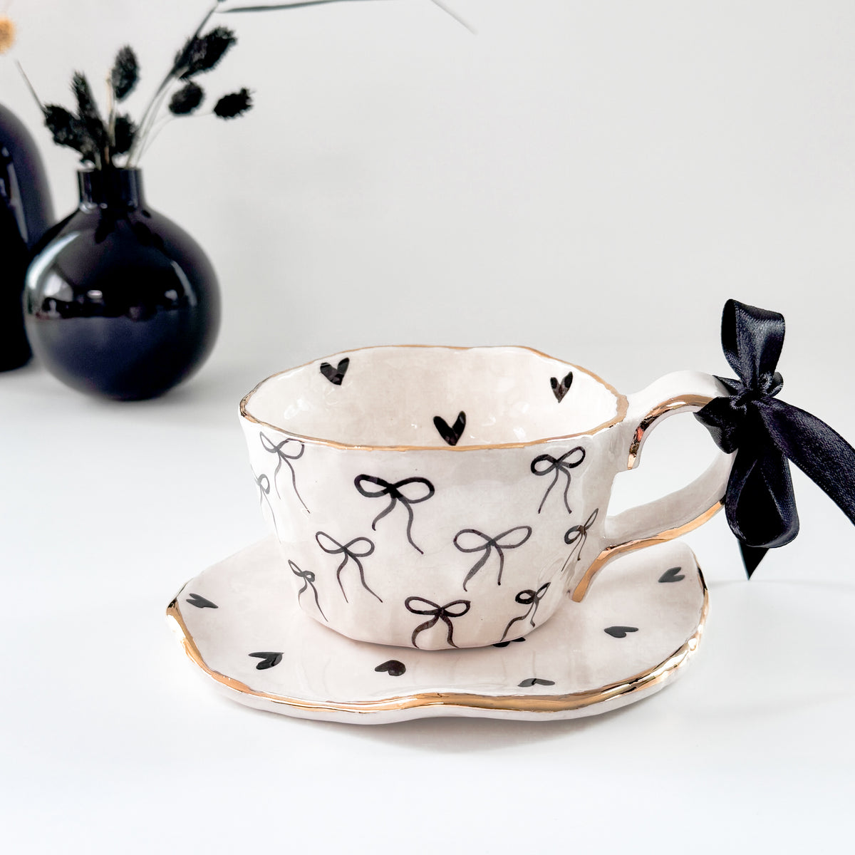Tasse mit Herzen und Schleifen, schwarz + Teller (handgeformt) aus Keramik | Handgefertigte Keramiktasse